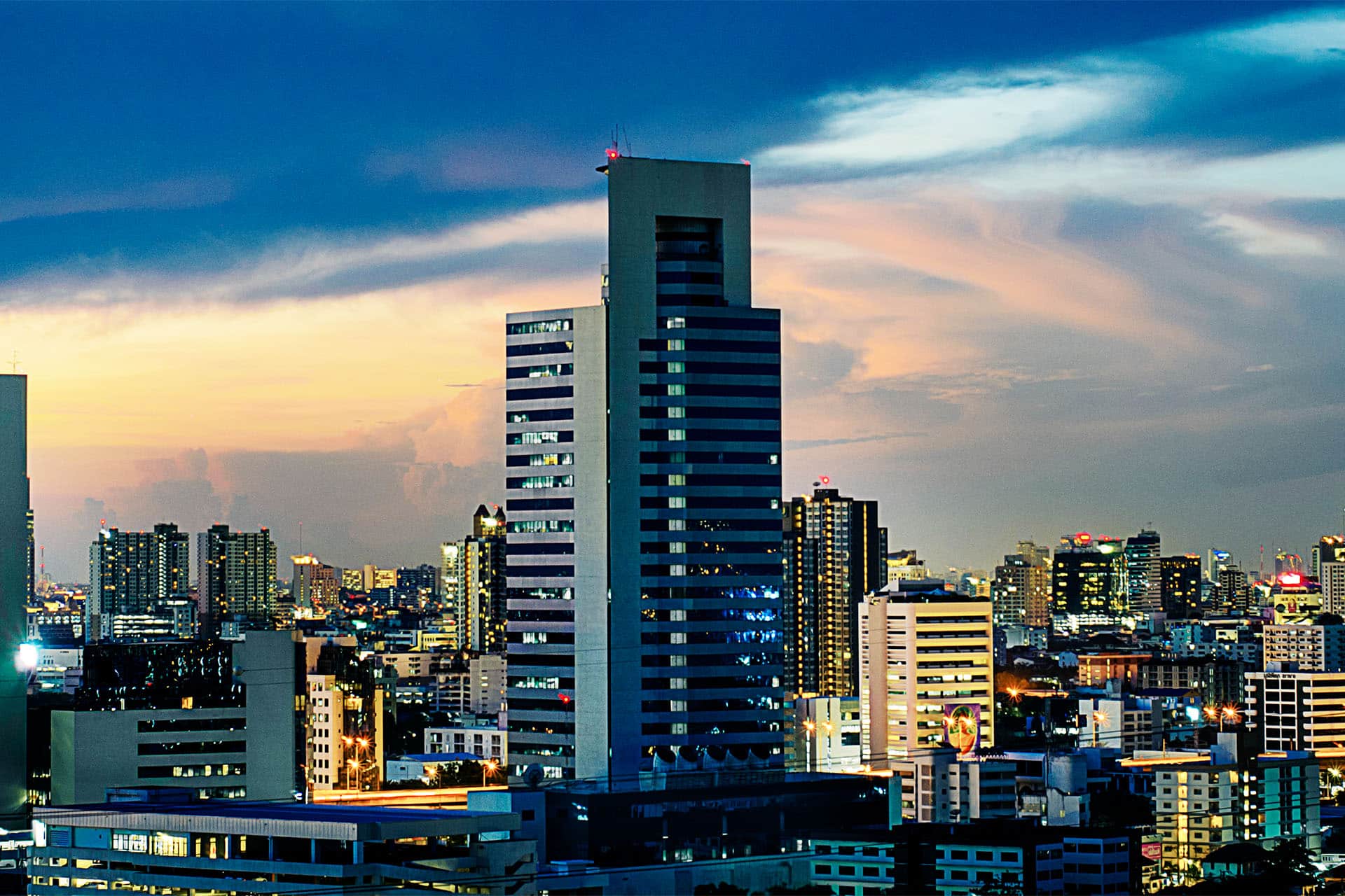 Modern high-rise buildings in Bangkok city centre at sunset, showcasing prime real estate and luxury condominiums in Thailand’s urban skyline.