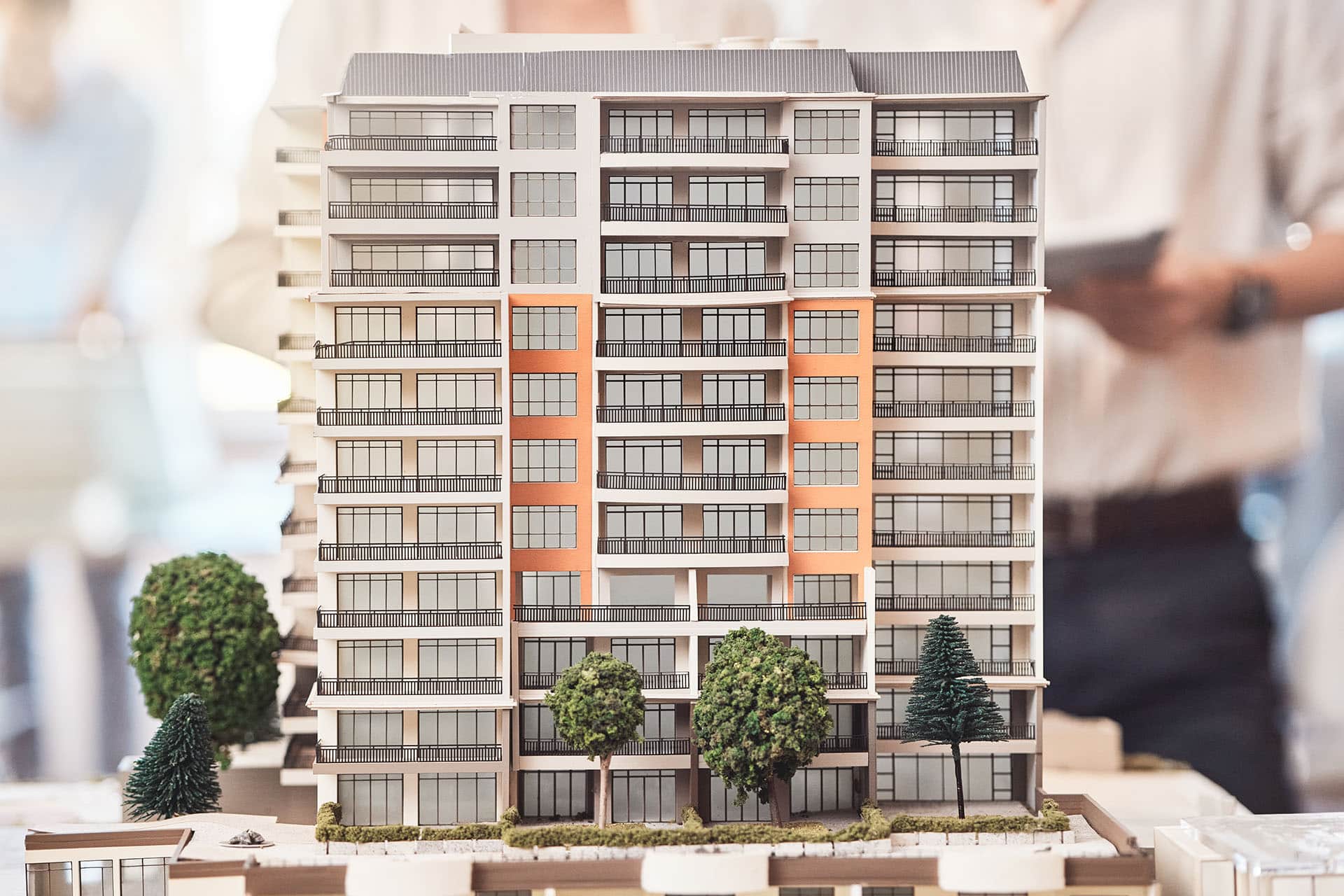 Architectural scale model of a modern condominium in Bangkok, showcasing residential units with balconies and landscaped surroundings.