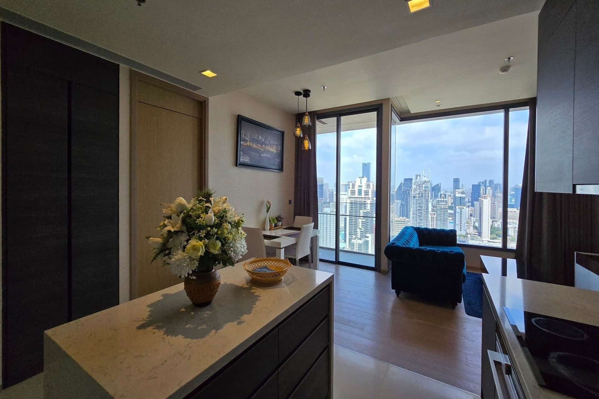 Modern condominium in Bangkok with stylish interior, floor-to-ceiling windows, and panoramic city skyline views.